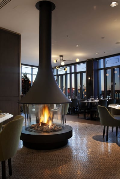 floor to ceiling view of ortal standalone fireplace at choux gras restaurant